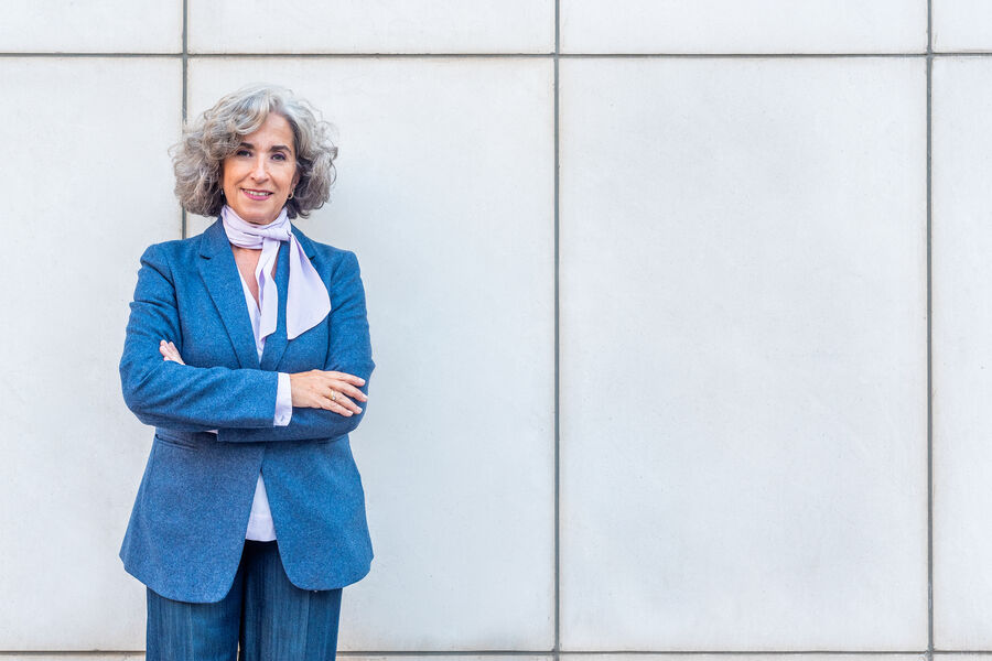 A confident woman in a blue blazer standing outdoors